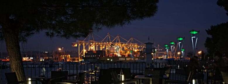 Der Hafen von Koper. Die Beleuchtung der Kräne erhellen die Nacht bis weit ins Hinterland. Die Geräuschkulisse kann bis ans Ende der Stadt wahrgenommen werden.